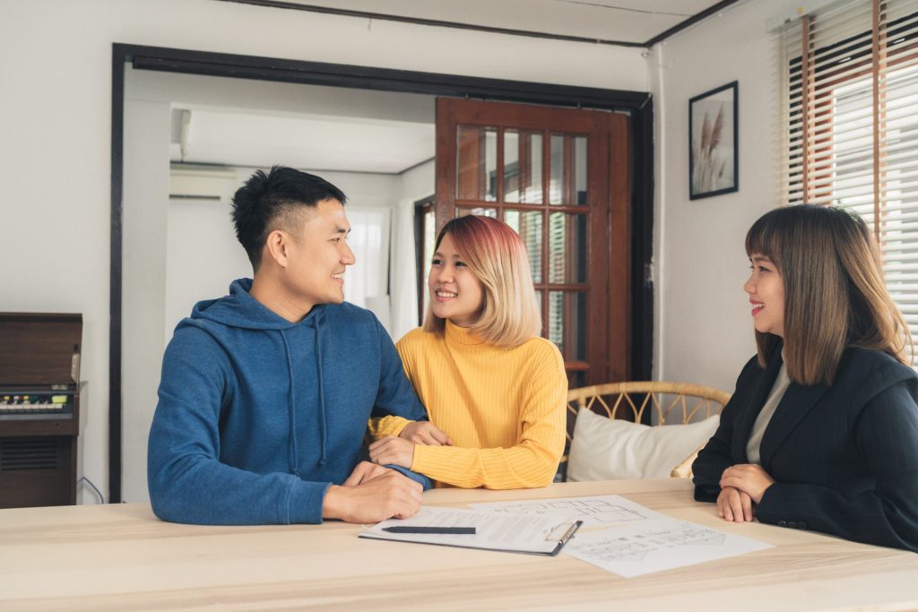 A young couple meets with a credit union representative in their home to discuss using a VA loan for a second home.